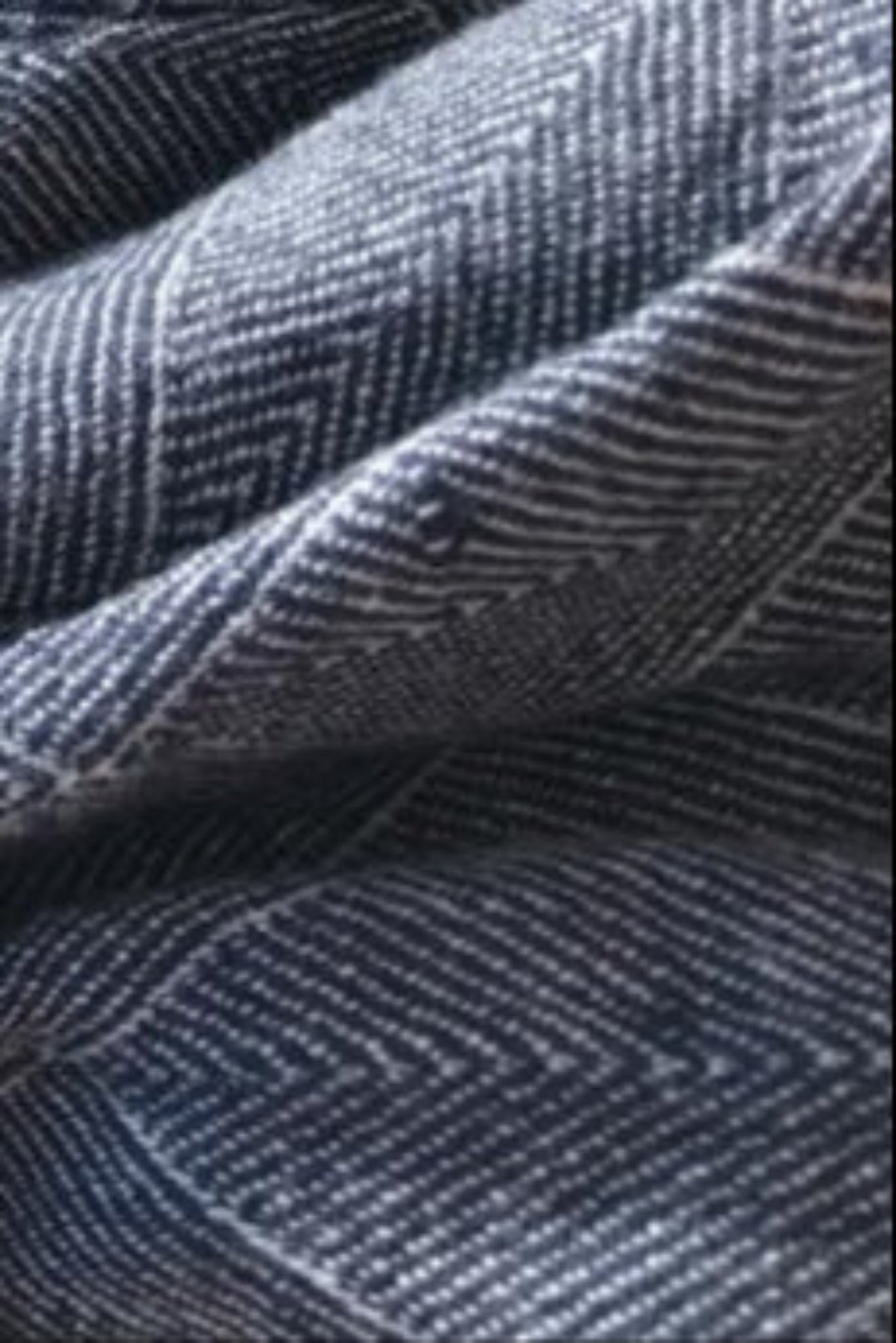 Close-up of blue denim fabric with a herringbone pattern