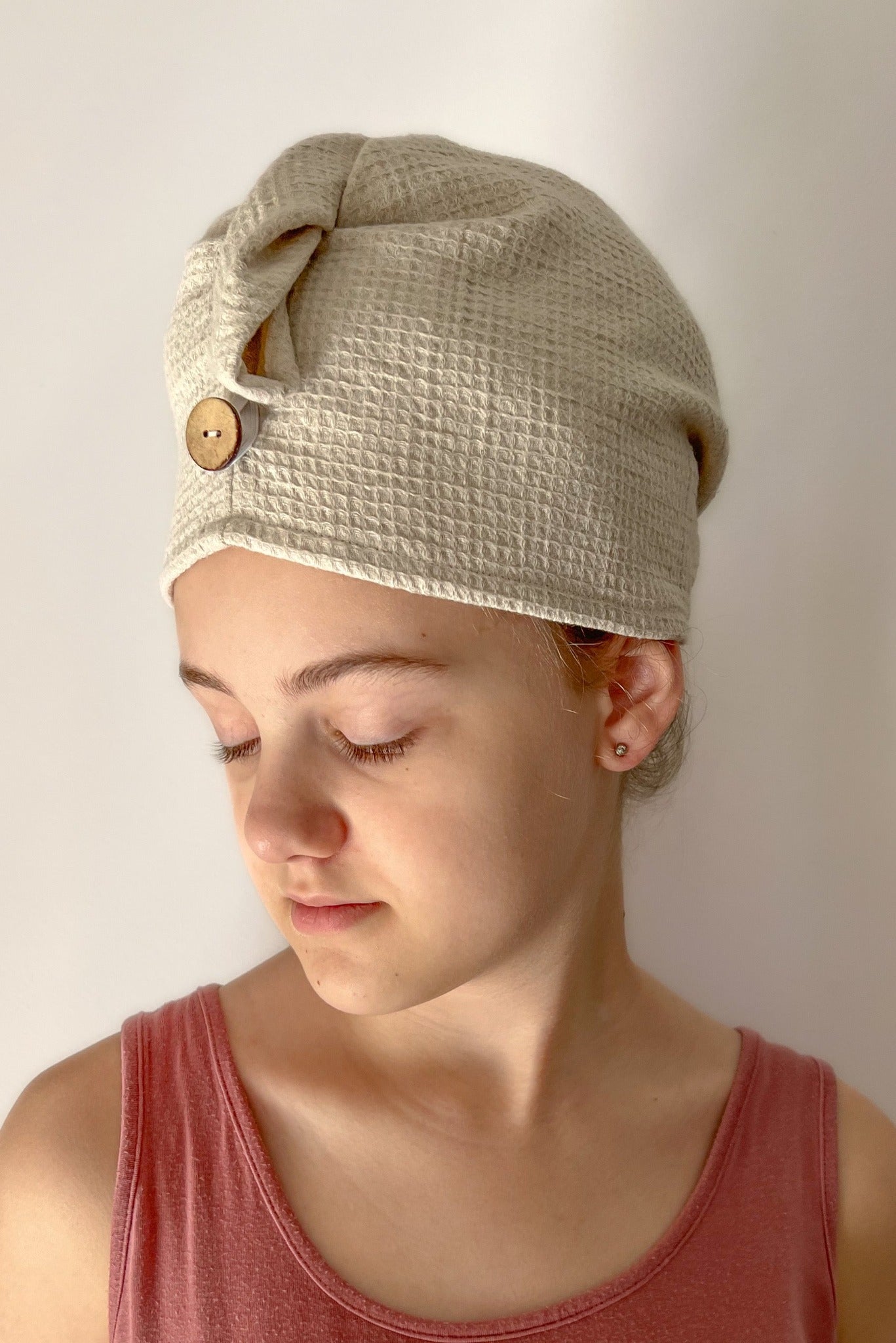 Girl in red tank top wearing light brown blanket hair wrap