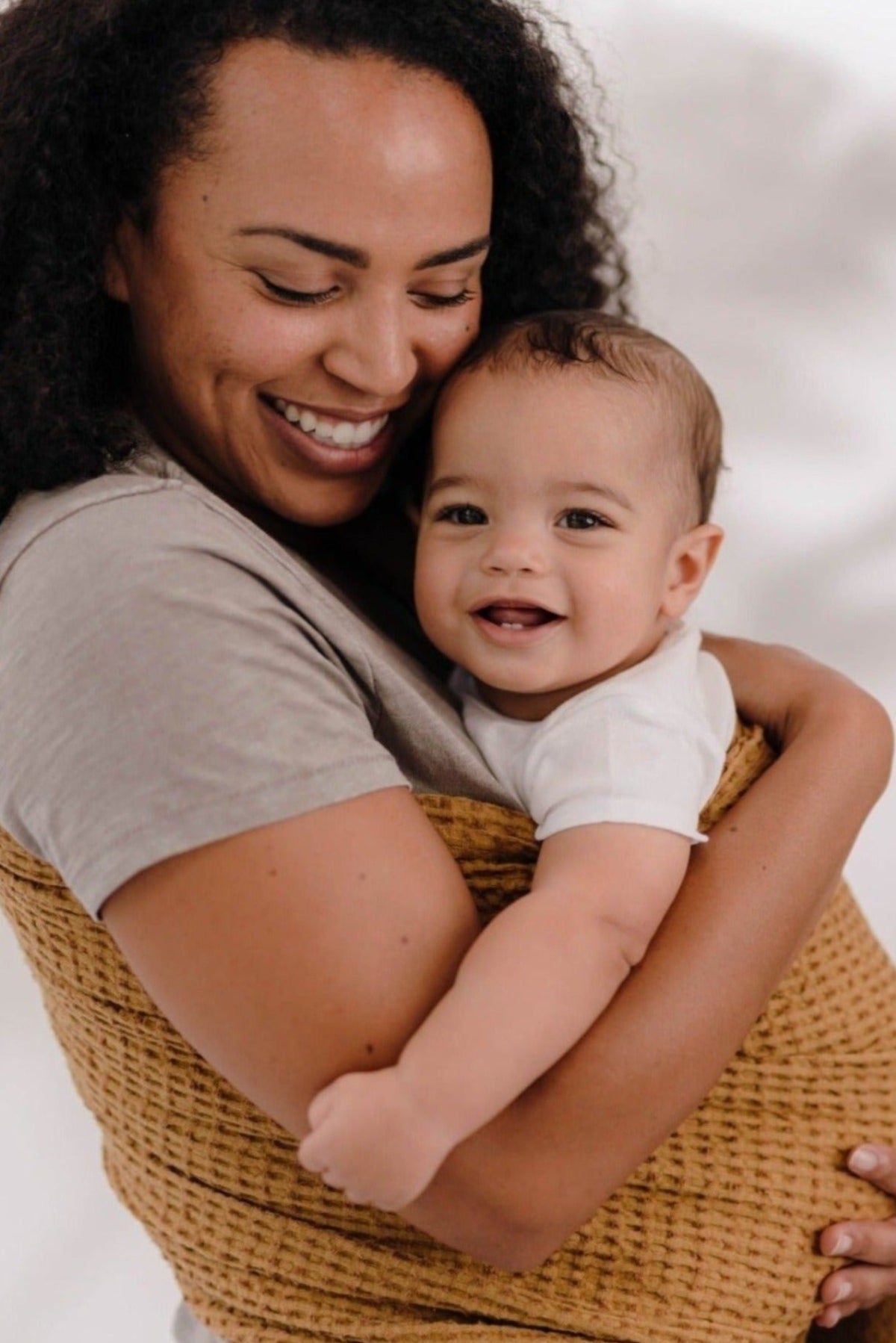 Women holding toddler in light brown ring sling carrier made of OekoTex