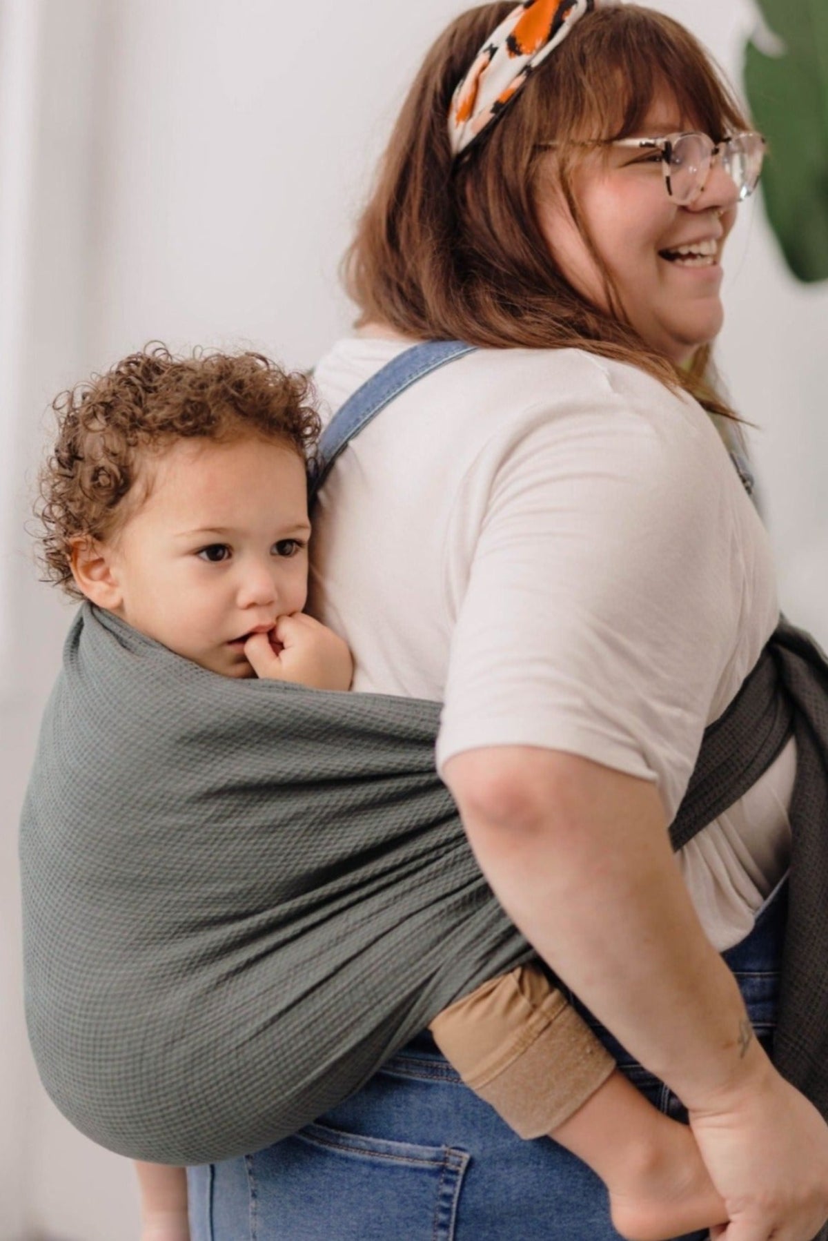 Women holding toddler in gray ring sling carrier made of OekoTex